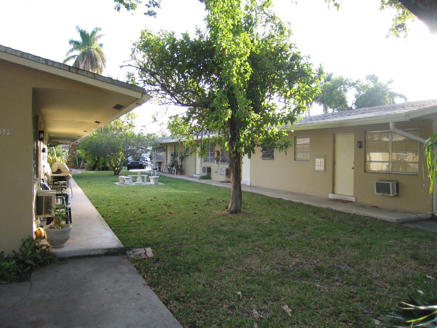 Courtyard with a tree between two building walkways under bright sunlight.