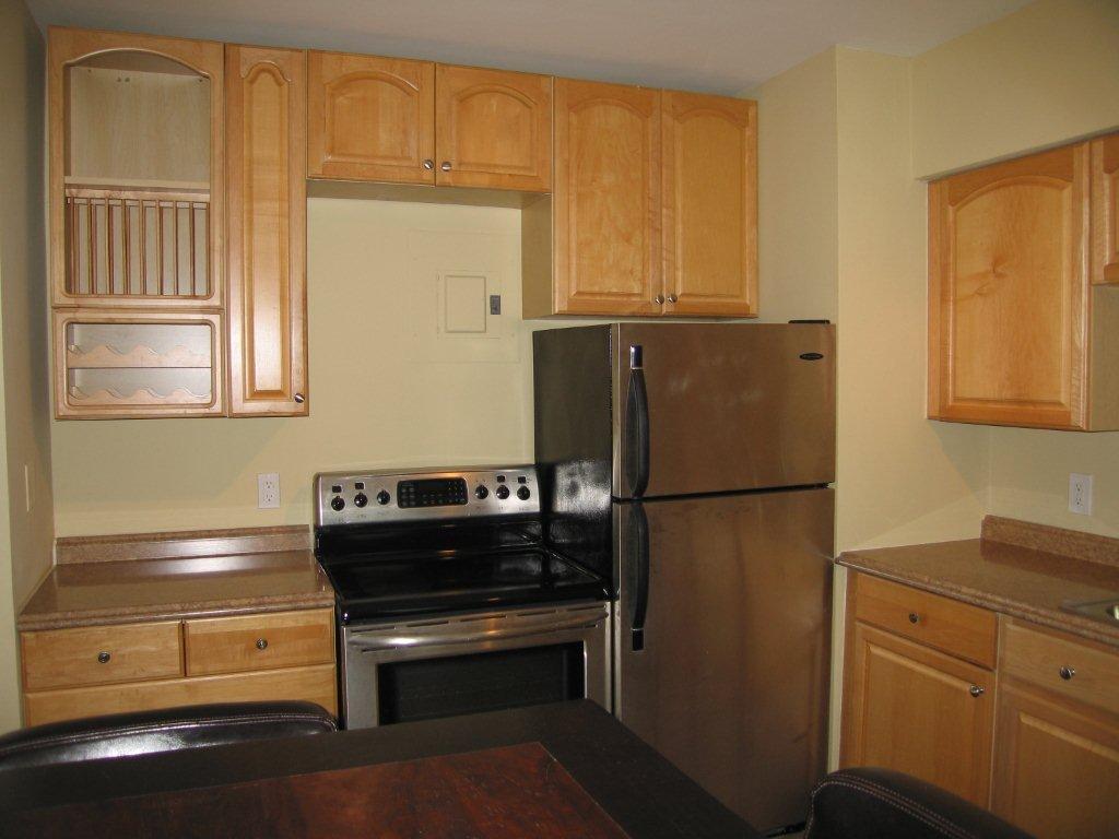 Modern kitchen with stainless steel appliances and wooden cabinets.