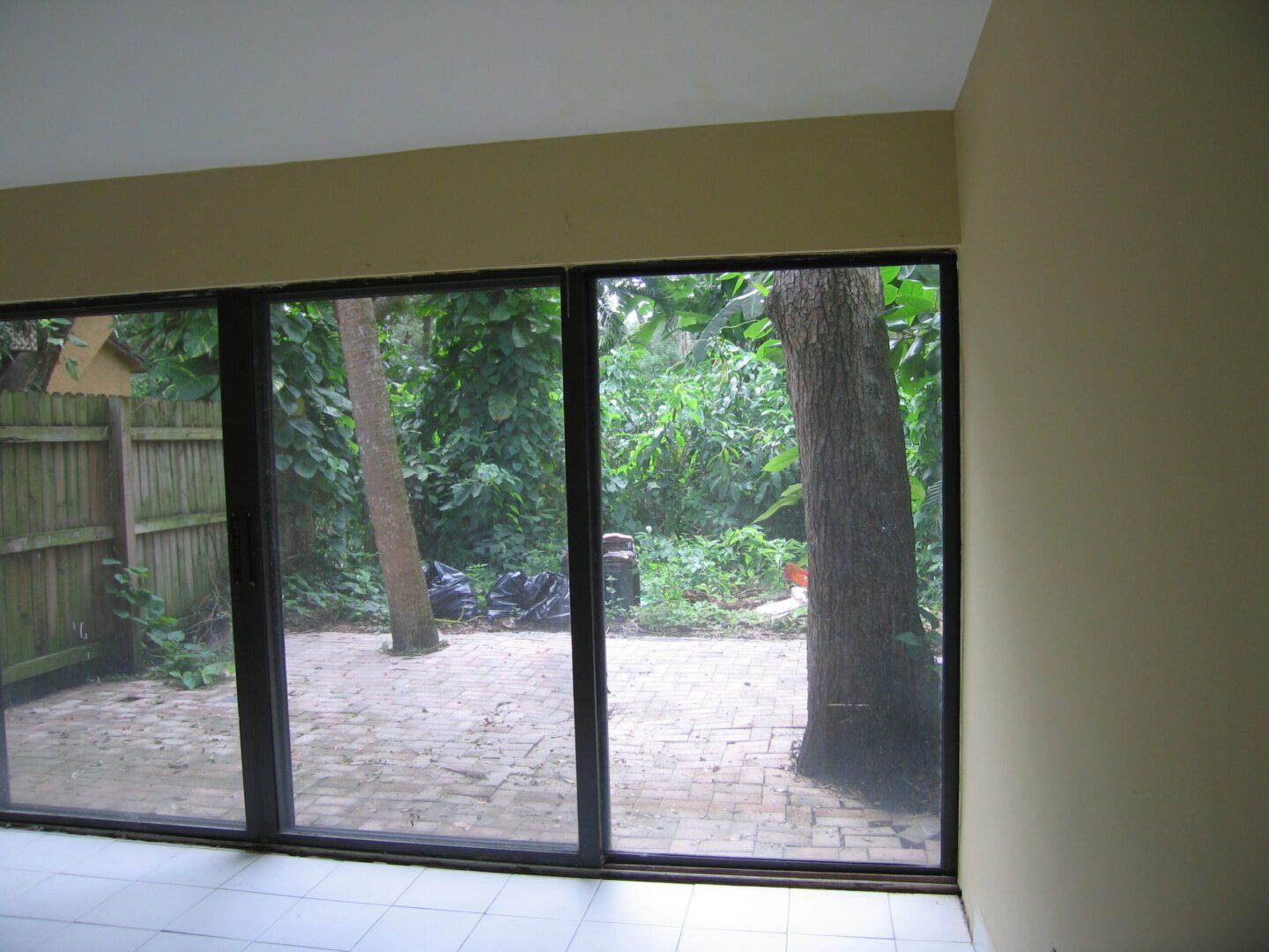 Sliding glass doors open to a wooded backyard.