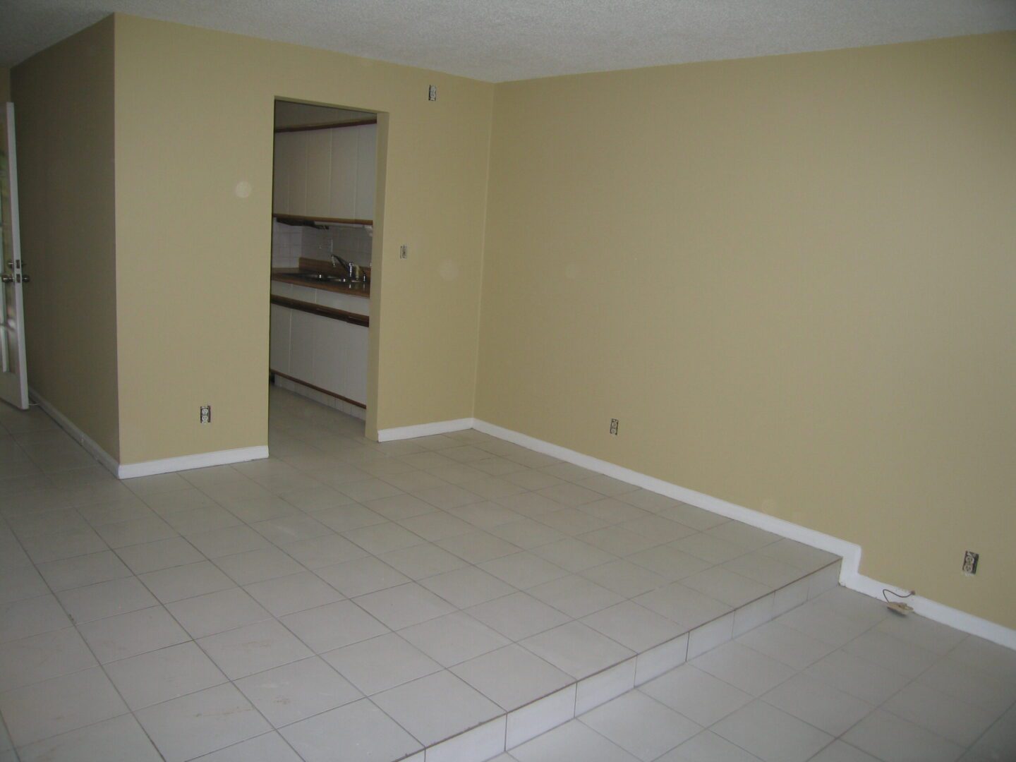 Empty room with tiled floor and beige walls.