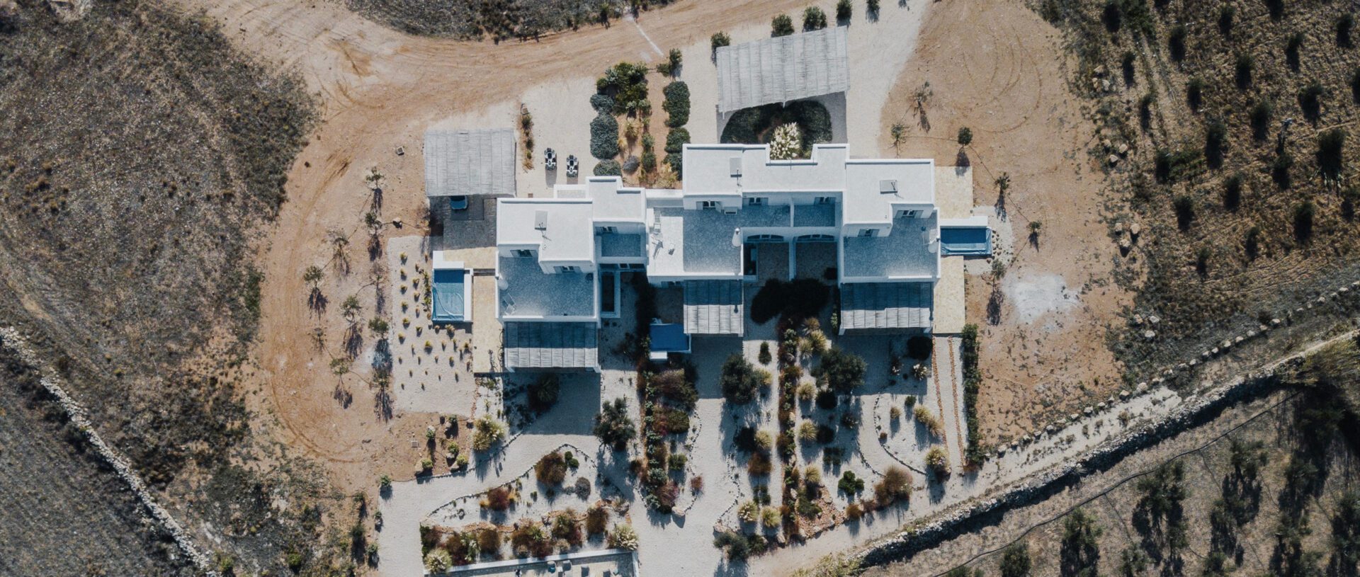 Aerial view of a modern building with surrounding gardens and pathways.